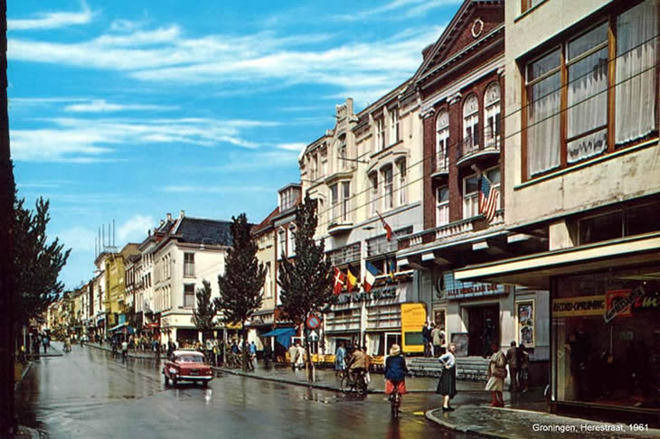 Groningen - De Herestraat gezien vanaf het Zuiderdiep, 1961. In het midden, met de vlaggen aan de gevel, het destijds befaamde hotel Frigge. Uiterst rechts C&A.
